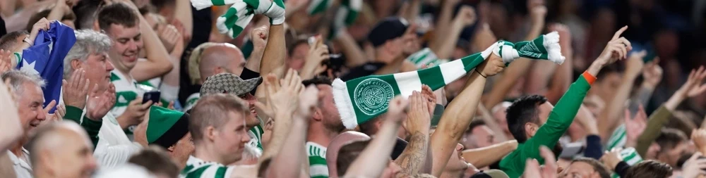 Begeisterte Fußballfans auf den Tribünen schwenken grün-weiße Schals und Flaggen im Stadion. Die einzigartige und leidenschaftliche Atmosphäre macht eine Fußballreise nach Schottland zu einem unvergesslichen Erlebnis für jeden Fan.