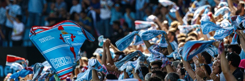 Celta de Vigo supporters in het stadion Sfeervolle tribune vol met Celta de Vigo supporters die lichtblauwe clubvlaggen en sjaals omhoog houden tijdens een thuiswedstrijd in Balaídos.